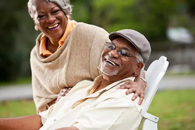 man smiling with his wife after restorative dentistry procedure in Havertown, PA